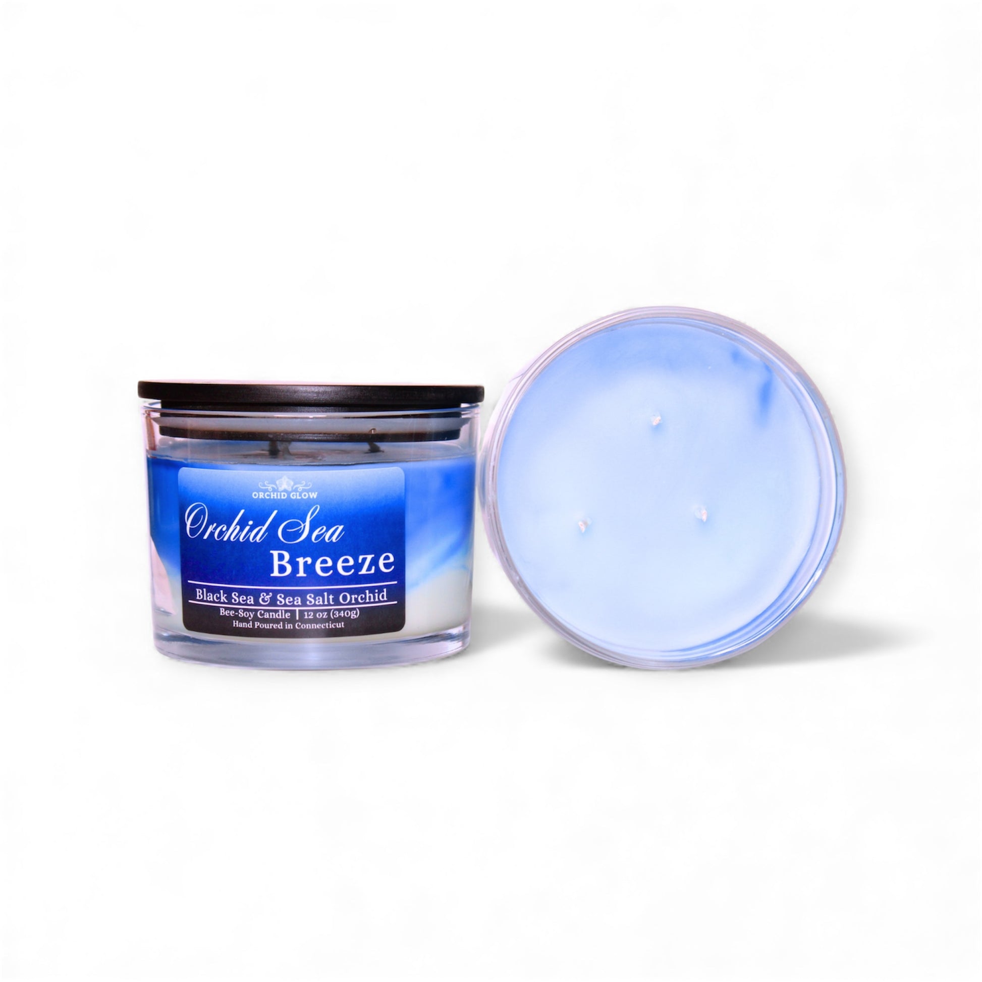 Candle jar labeled 'Orchid Sea Breeze' with lid off on a white background