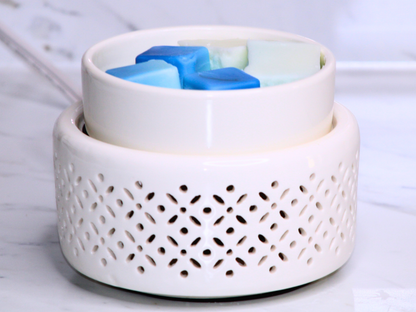 White wax warmer with blue wax cubes on a marble surface
