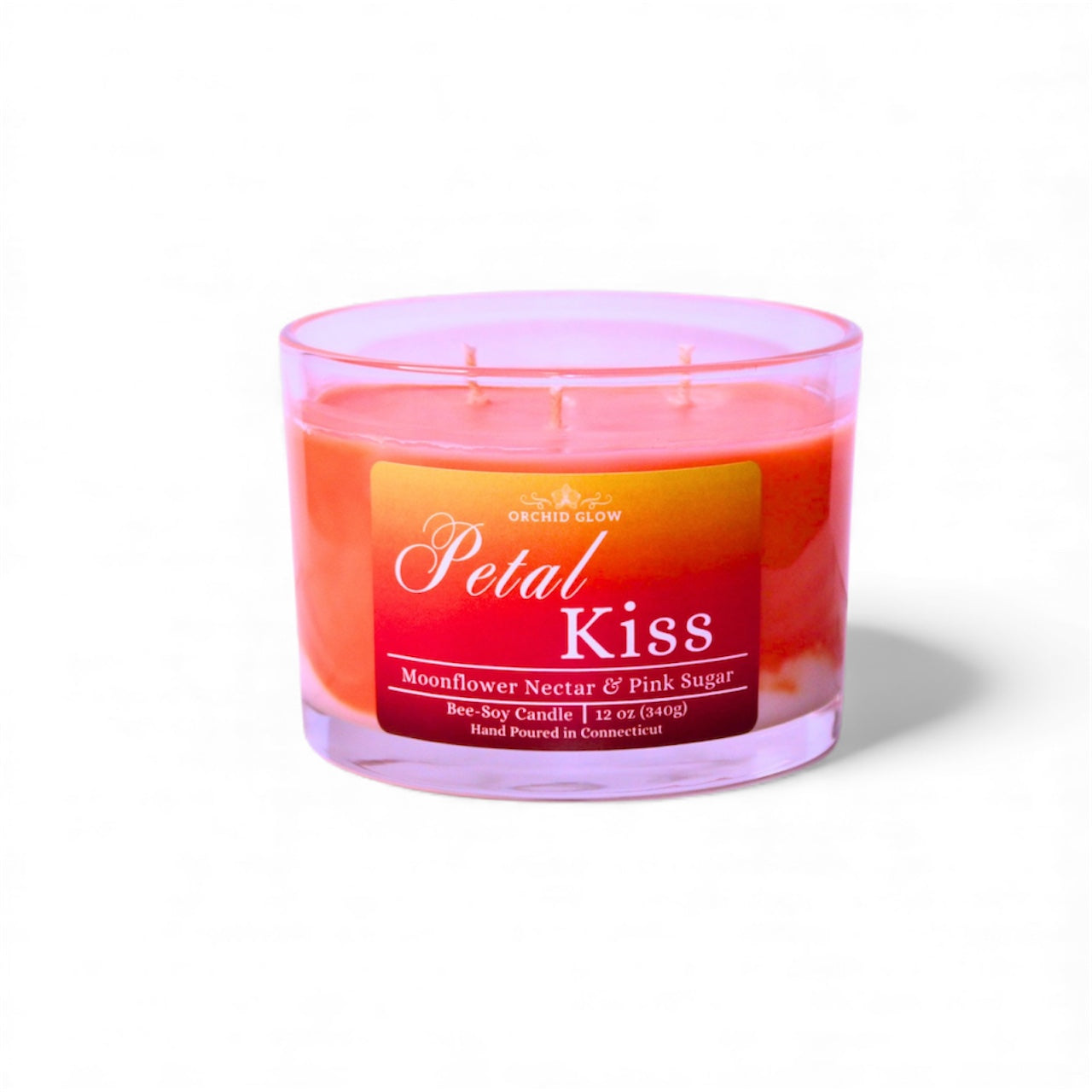 Candle labeled 'Petal Kiss' with a pink and red design on a white background