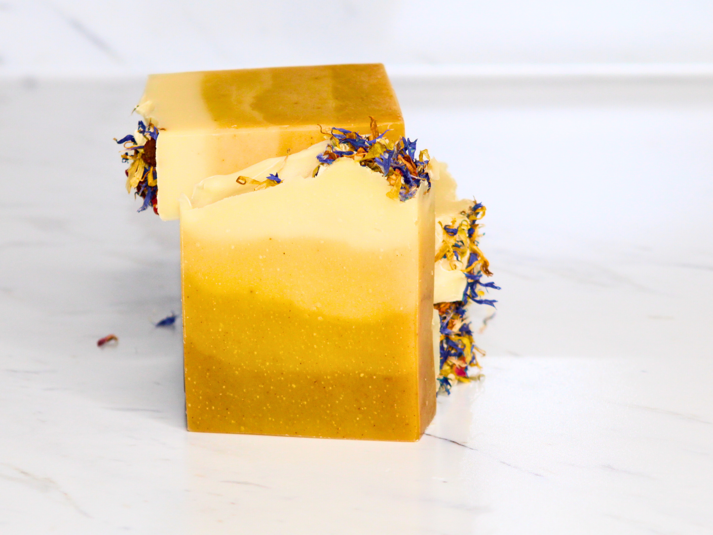 Yellow soap bar with decorative elements on a marble surface